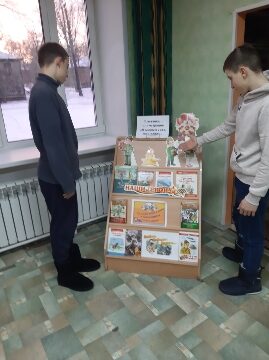 участники на фоне книжной выставки